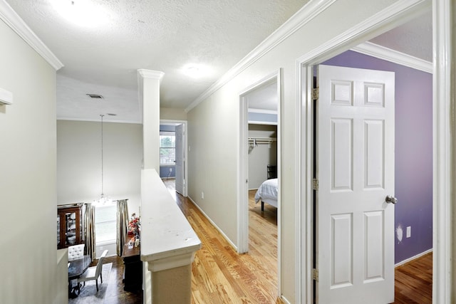 3002 Trinity Pass Ct, Spring, TX 77373 - corridor featuring light wood-style floors, ornamental molding, and a textured ceiling