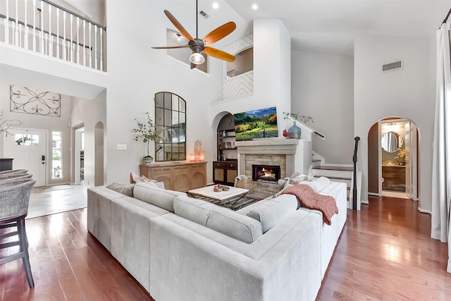 14222 Autumn Mist, Cypress, TX 77429 - living area featuring high vaulted ceiling, arched walkways, ceiling fan, a stone fireplace, and wood finished floors