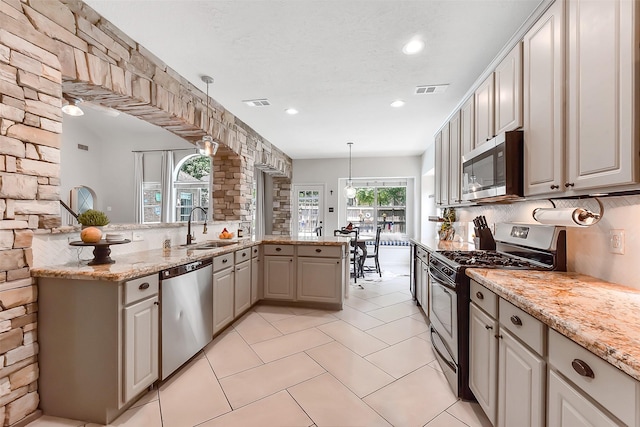 14222 Autumn Mist, Cypress, TX 77429 - kitchen featuring stainless steel appliances, a sink, hanging light fixtures, recessed lighting, and light stone countertops