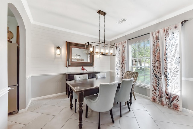 14222 Autumn Mist, Cypress, TX 77429 - dining room featuring arched walkways, baseboards, light tile patterned flooring, crown molding, and wood walls