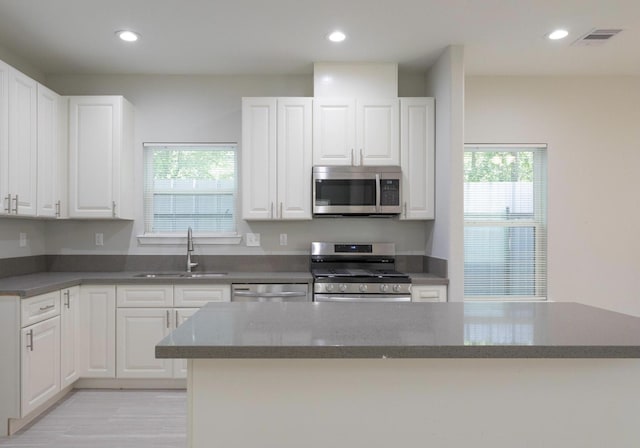 5801 Phillips St, Houston, TX 77091 - kitchen featuring stainless steel appliances, a sink, plenty of natural light, white cabinetry, and recessed lighting