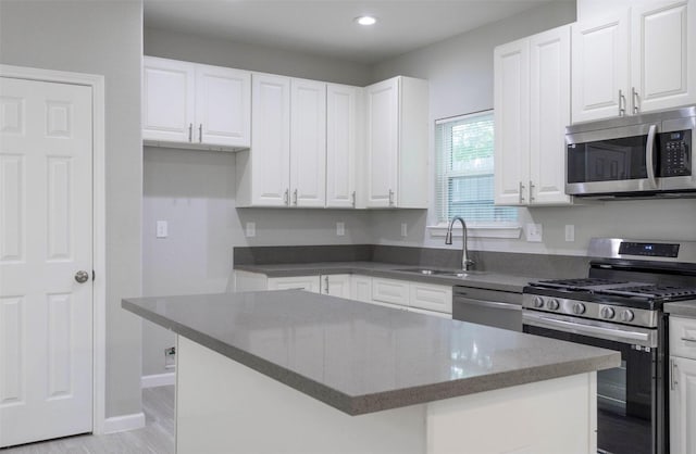 5801 Phillips St, Houston, TX 77091 - kitchen featuring stainless steel appliances, a sink, white cabinetry, recessed lighting, and a kitchen island