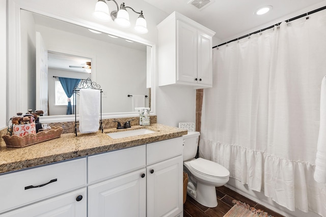 1603 Culture Ln, College Station, TX 77845 - bathroom with toilet, vanity, wood finished floors, ceiling fan, and recessed lighting