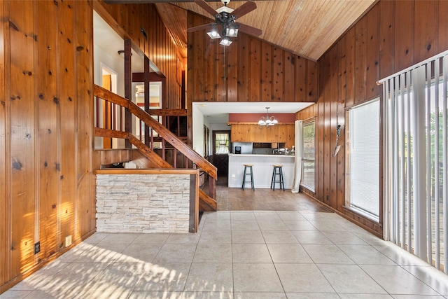 7 Lake Dr, Huntsville, TX 77320 - unfurnished living room featuring wood walls, high vaulted ceiling, a chandelier, wood ceiling, and tile patterned floors