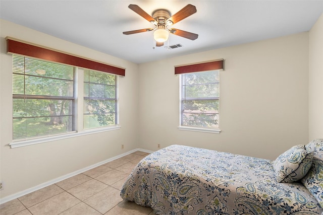 7 Lake Dr, Huntsville, TX 77320 - bedroom with multiple windows, light tile patterned flooring, baseboards, and ceiling fan