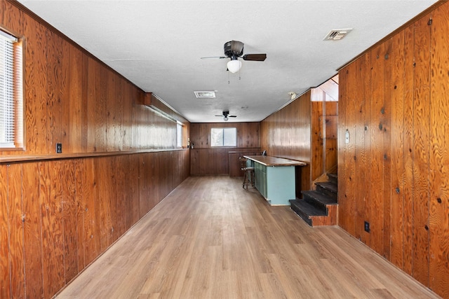 7 Lake Dr, Huntsville, TX 77320 - bar area featuring light wood-type flooring, ceiling fan, wood walls, and stairway