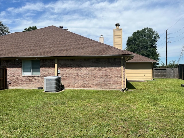 10406 Friars Hill Ln, Houston, TX 77070 - rear view of house featuring central AC, a chimney, brick siding, and roof with shingles