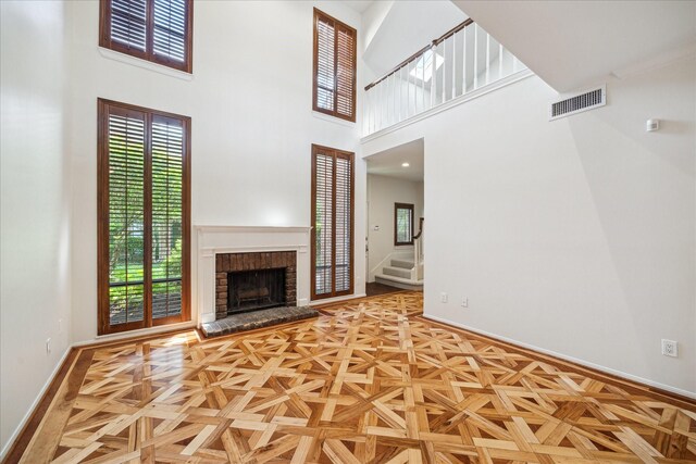 2901 Bammel Ln Unit 17, Houston, TX 77098 - unfurnished living room with a high ceiling, baseboards, stairs, and a brick fireplace
