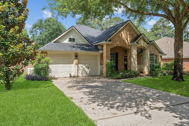 2504 N Yorkchase Ln, Conroe, TX 77304 - traditional-style house with an attached garage, roof with shingles, a front yard, and brick siding
