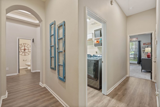 2504 N Yorkchase Ln, Conroe, TX 77304 - hall featuring arched walkways, wood finished floors, independent washer and dryer, and baseboards