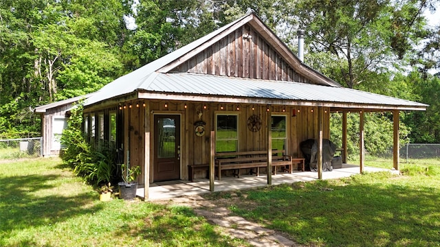 2301 Hines Lake Rd, Coldspring, TX 77331 - view of front of home with board and batten siding, metal roof, and a patio area