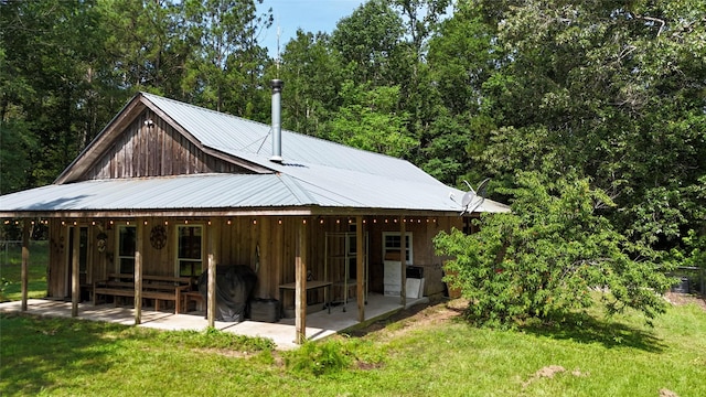 2301 Hines Lake Rd, Coldspring, TX 77331 - rear view of house featuring a lawn, a patio area, and metal roof
