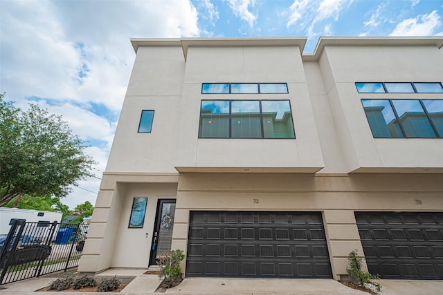 72 N Hutcheson St, Houston, TX 77003 - view of front facade featuring an attached garage, stucco siding, and concrete driveway