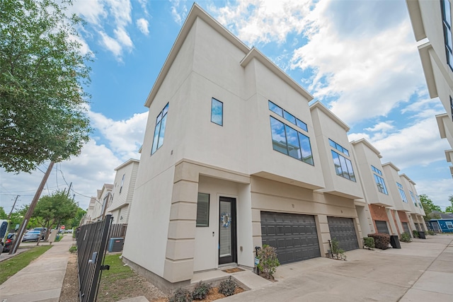 72 N Hutcheson St, Houston, TX 77003 - view of building exterior with a garage, a residential view, driveway, and central AC