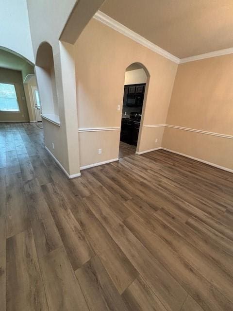 995 Arbor Gln, Conroe, TX 77303 - empty room with arched walkways, dark wood-style floors, baseboards, and crown molding