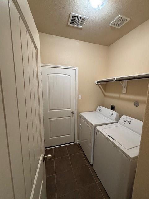 995 Arbor Gln, Conroe, TX 77303 - washroom featuring washing machine and dryer, dark tile patterned flooring, and a textured ceiling