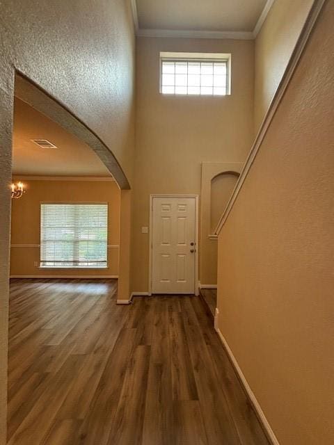 995 Arbor Gln, Conroe, TX 77303 - entrance foyer with crown molding, wood finished floors, baseboards, arched walkways, and a chandelier