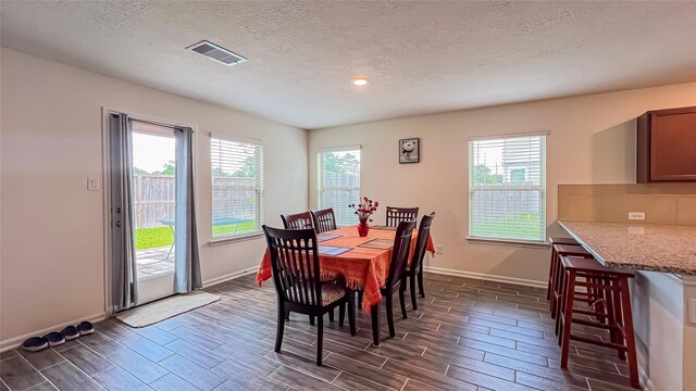 706 Hardwood Grove Ct, Houston, TX 77090 - dining area with wood tiled floors, baseboards, and a textured ceiling