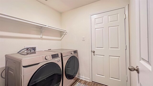 706 Hardwood Grove Ct, Houston, TX 77090 - laundry area with washer and dryer, dark wood-type flooring, and baseboards