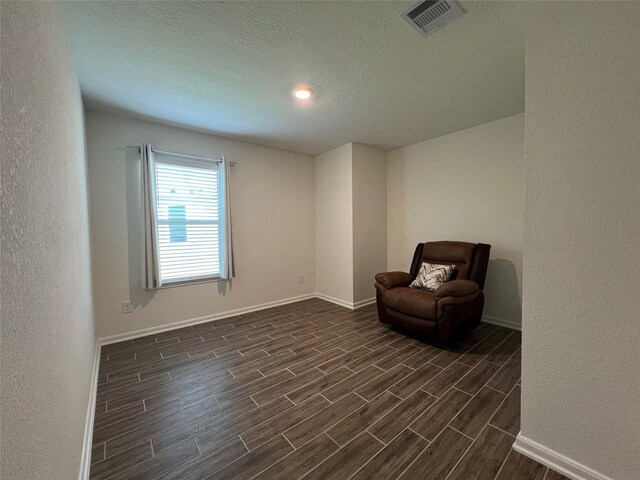 706 Hardwood Grove Ct, Houston, TX 77090 - sitting room with dark wood-style flooring, baseboards, a textured ceiling, and a textured wall