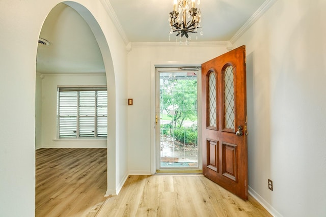 204 Caladium St, Lake Jackson, TX 77566 - foyer featuring wood finished floors, ornamental molding, arched walkways, baseboards, and a chandelier