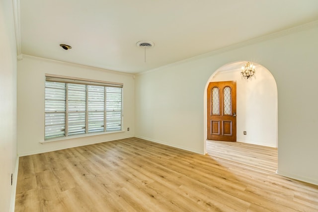 204 Caladium St, Lake Jackson, TX 77566 - unfurnished room with arched walkways, crown molding, light wood-style floors, a chandelier, and baseboards