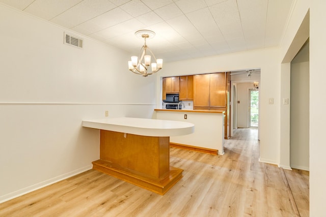 204 Caladium St, Lake Jackson, TX 77566 - kitchen featuring a peninsula, a chandelier, crown molding, light wood finished floors, and light countertops