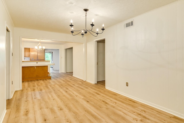 204 Caladium St, Lake Jackson, TX 77566 - unfurnished dining area featuring a chandelier, light wood-style flooring, ornamental molding, and baseboards
