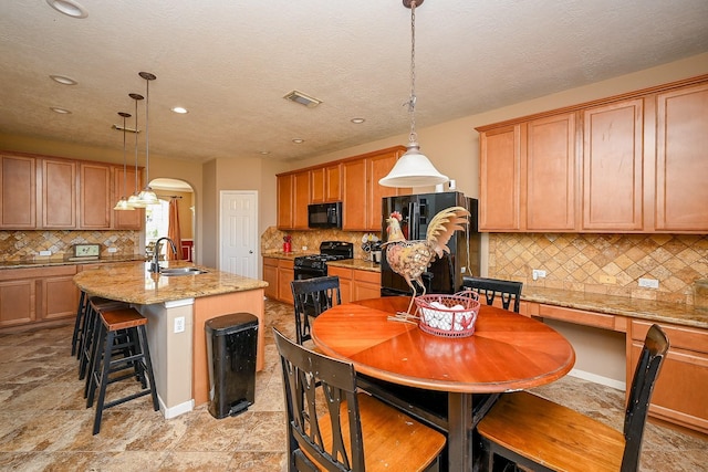 4214 Bridgestone Shadow Ct, Spring, TX 77388 - kitchen with black appliances, a sink, decorative backsplash, a kitchen island with sink, and recessed lighting