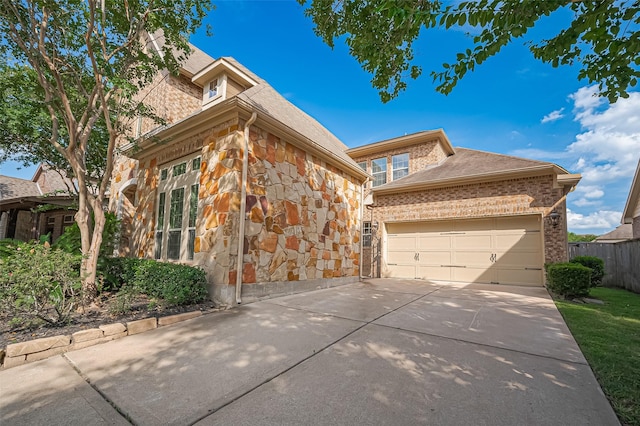 10002 Hutton Park Dr, Katy, TX 77494 - view of front of home with stone siding, concrete driveway, and a garage