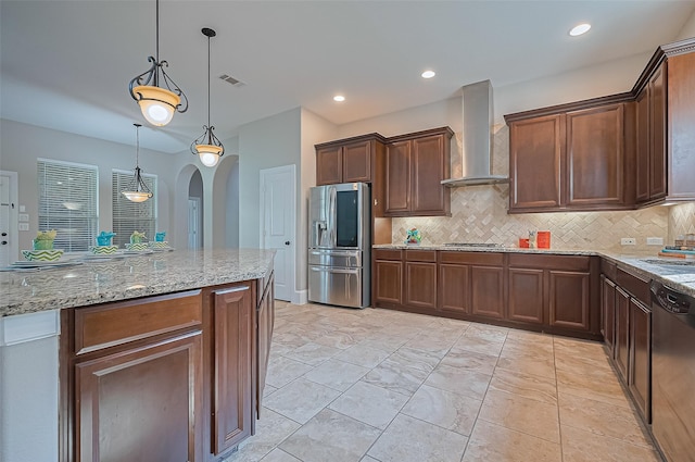 10002 Hutton Park Dr, Katy, TX 77494 - kitchen with stainless steel appliances, wall chimney range hood, arched walkways, tasteful backsplash, and light stone countertops