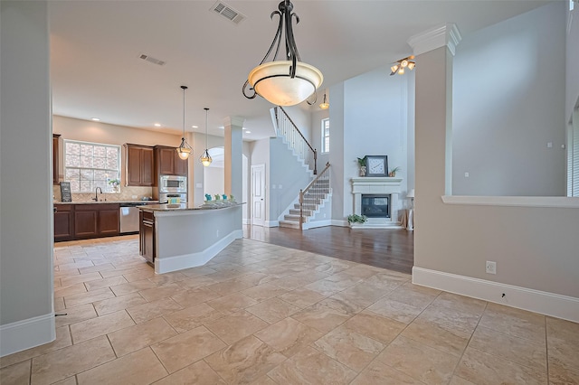 10002 Hutton Park Dr, Katy, TX 77494 - kitchen featuring stainless steel appliances, a sink, open floor plan, baseboards, and backsplash