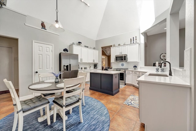 2206 E Van Trease Dr, Deer Park, TX 77536 - kitchen featuring stainless steel appliances, high vaulted ceiling, a sink, a kitchen island, and light tile patterned floors