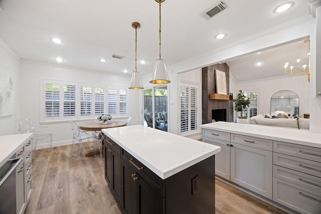 12302 Overcup Dr, Houston, TX 77024 - kitchen with light countertops, a kitchen island, ornamental molding, light wood finished floors, and healthy amount of natural light
