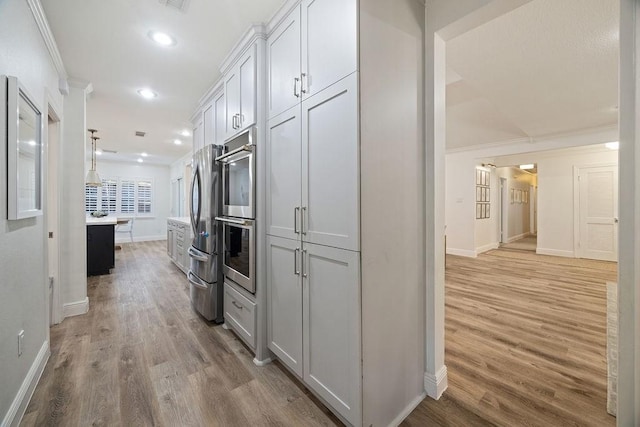 12302 Overcup Dr, Houston, TX 77024 - kitchen with baseboards, crown molding, light wood-style flooring, appliances with stainless steel finishes, and recessed lighting