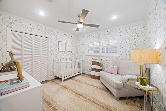 12302 Overcup Dr, Houston, TX 77024 - bedroom featuring crown molding, wallpapered walls, a closet, recessed lighting, and a crib