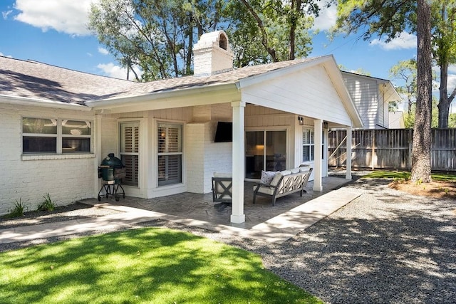 12302 Overcup Dr, Houston, TX 77024 - back of property featuring a chimney, brick siding, a patio area, and a shingled roof