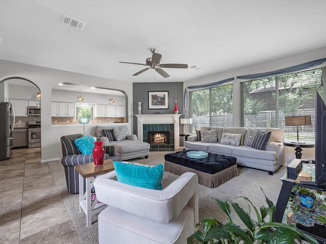 2710 Magnolia Walk, Spring, TX 77388 - living room with ceiling fan, a tile fireplace, and arched walkways