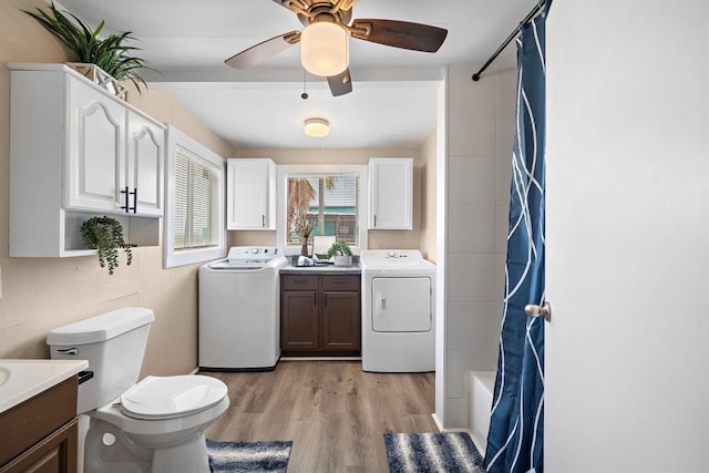 514 Texas, Surfside Beach, TX 77541 - bathroom featuring vanity, wood finished floors, ceiling fan, washing machine and dryer, and shower / bath combo with shower curtain