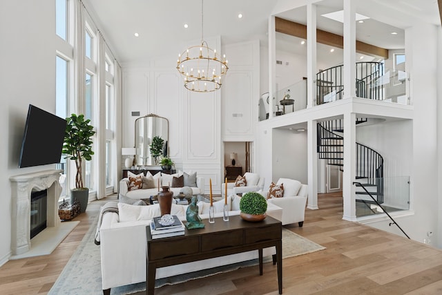 102 Lanai St, Tiki Island, TX 77554 - living area with high vaulted ceiling, stairway, plenty of natural light, a chandelier, and light wood-style floors