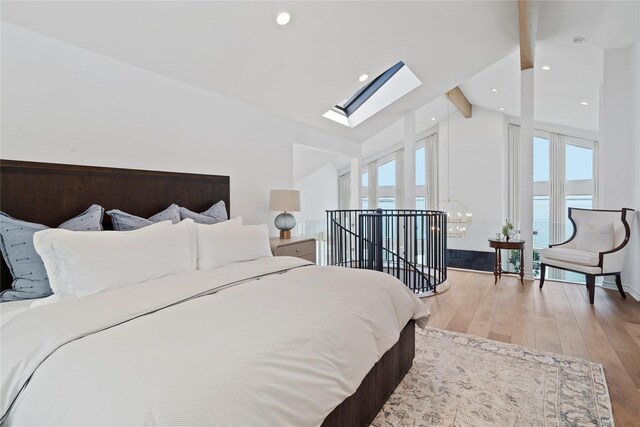 102 Lanai St, Tiki Island, TX 77554 - bedroom with multiple windows, a skylight, beam ceiling, light wood-type flooring, and a chandelier