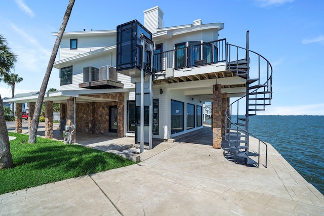 102 Lanai St, Tiki Island, TX 77554 - back of house with stairway, a balcony, a chimney, and a water view