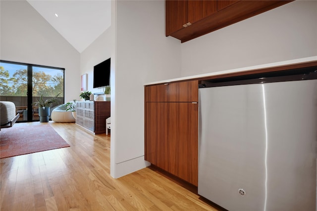 1136 Aurora St, Houston, TX 77009 - bedroom with light wood-style floors, high vaulted ceiling, and refrigerator