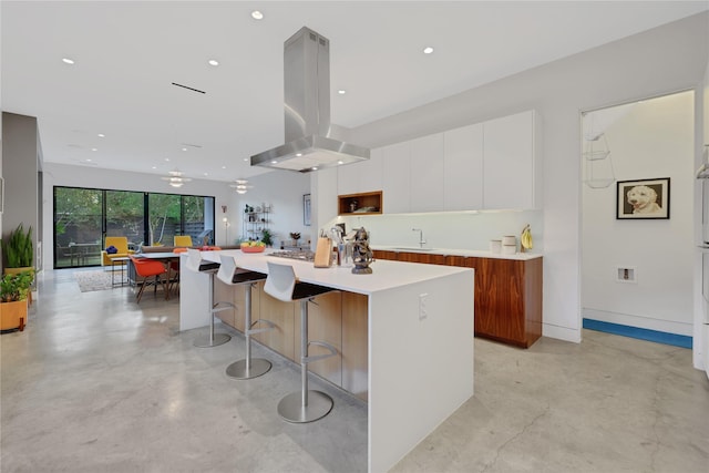 1136 Aurora St, Houston, TX 77009 - kitchen featuring modern cabinets, concrete flooring, island range hood, white cabinetry, and a kitchen island