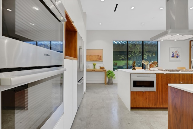 1136 Aurora St, Houston, TX 77009 - kitchen featuring modern cabinets, appliances with stainless steel finishes, brown cabinetry, island range hood, and concrete floors