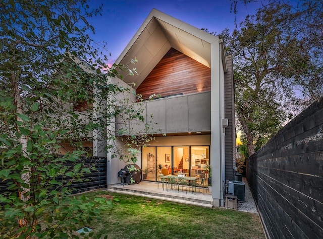 1136 Aurora St, Houston, TX 77009 - back of property at dusk with cooling unit and a patio