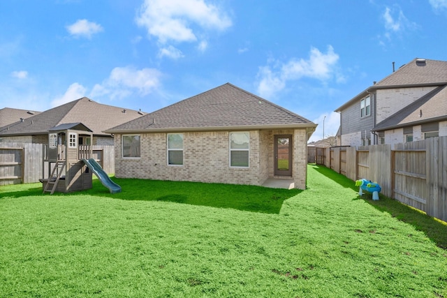 20010 Sienna Green Dr, Hockley, TX 77447 - rear view of house with brick siding, a playground, and a shingled roof