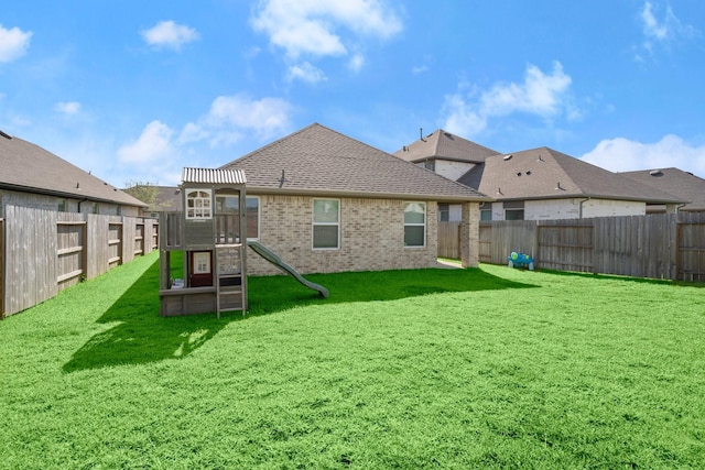20010 Sienna Green Dr, Hockley, TX 77447 - rear view of property featuring a playground, brick siding, and roof with shingles