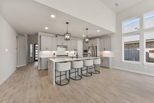 5107 Shimmering Brook Ln, Fulshear, TX 77441 - kitchen with stainless steel appliances, a sink, a breakfast bar area, light countertops, and baseboards