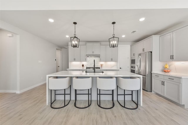 5107 Shimmering Brook Ln, Fulshear, TX 77441 - kitchen with appliances with stainless steel finishes, a breakfast bar, decorative backsplash, baseboards, and recessed lighting